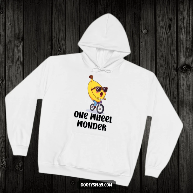 Funny banana hoodie, surprised expression, wearing tiny sunglasses, riding a unicycle. Cozy and humorous apparel for a good laugh.