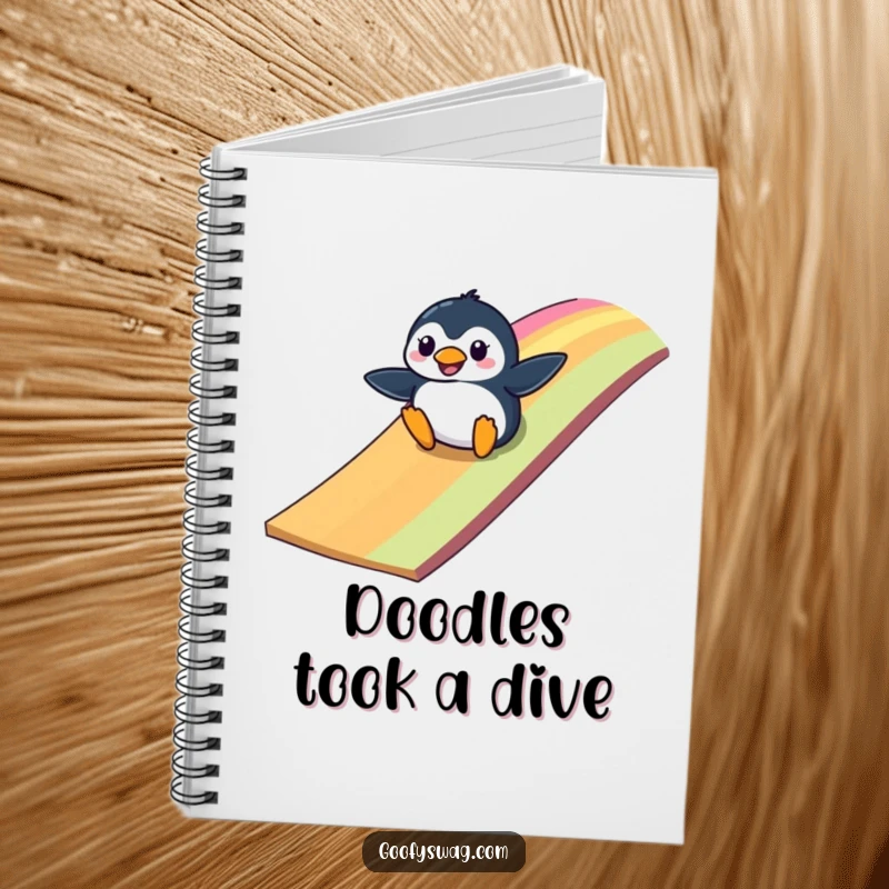 Funny clumsy penguin sliding down a colorful rainbow ramp, a humorous notebook for creative minds and planners.